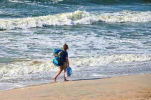 Woman backpacker traveling, beautiful Baltic Sea background. Solo female travel trip with backpack photo
