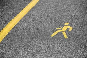 Yellow pedestrian sign on sidewalk, road yellow marking for traffic safety near highway photo