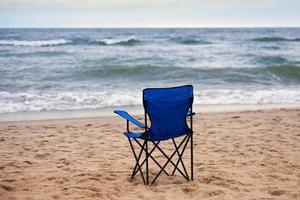 silla plegable azul en la playa, sin gente, vacaciones en la playa solas, soledad foto