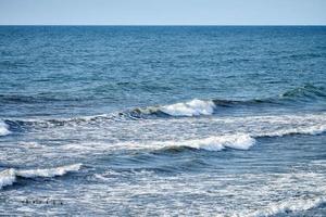 Deep blue sea waters splashing with foamy waves, dark blue wavy ocean water surface, copy space photo