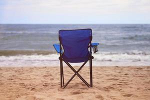 silla plegable azul en la playa, sin gente, vacaciones en la playa solas, soledad foto