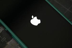 iphone 13 pro con el logotipo de apple cargando e instalando el sistema operativo ios 15.5 en la pantalla de cerca, nuevo ios 2022 en dispositivos apple sub v. ios 15 para actualizaciones bangkok, tailandia - 29 de mayo de 2022 foto