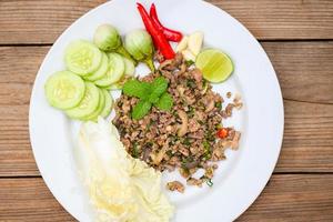 cooking duck , spicy minced duck salad with herb spices fresh vegetable eggplant cucumber chinese cabbage garlic chili lime and mint leaf - Asian Thai Food photo