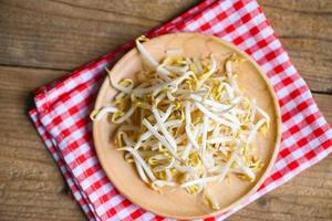 Bean sprouts on wooden plate table background in the kitchen, Raw white organic bean sprouts or mung bean sprout for food vegan photo