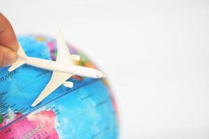 Business man holding airliner aircraft plane on world globe background - worldwide travel concept photo