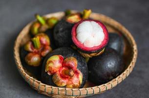 Mangosteen on basket and dark background, fresh ripe mangosteen peeled from tree at tropical fruit Thailand in summer photo