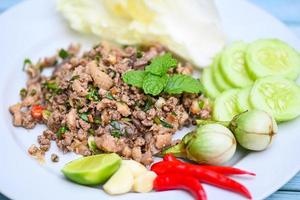 cooking duck , spicy minced duck salad with herb spices fresh vegetable eggplant cucumber chinese cabbage garlic chili lime and mint leaf - Asian Thai Food photo