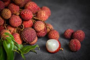 Lychee fruit with green leaf on black background, fresh ripe lychee peeled from lychee tree at tropical fruit Thailand in summer photo