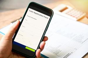 Loan Application Form on smartphone mobile application for  Loan financial help form concept, Technology online, hand holding mobile smartphone with business via online personal loan apply. photo