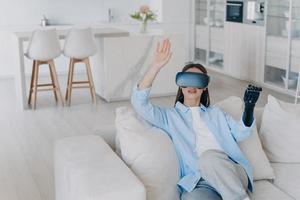 Caucasian handicapped girl in vr glasses. Disabled person gets rehabilitation for sensor cyber arm. photo