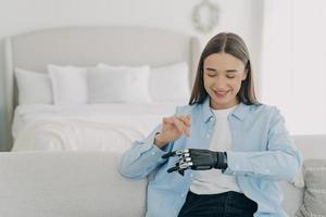Happy girl is setting her electronic bionic limb. Engineering and innovation concept. photo