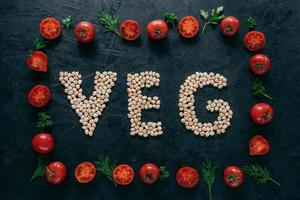 Vegetable frame made of tomatoes and green parsley, dill. Letter shaped garbanzo in middle. Raw vegetarian products. Healthy eating concept photo