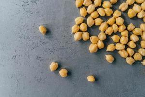 Healthy food concept. Protein nut seeds spill on grey background, copy space for text. Chickpea beans for tasty protein nutrition. photo