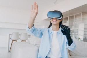 Handicapped girl gets rehabilitation in vr glasses. Amputee with bionic limb prosthesis. photo