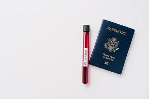 Travel restrictions, quarantine and coronavirus concept. Blood sample in tube and passport on white background. Gloabl pandemic outbreak. Airport security check photo