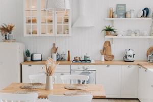 Scandinavian kitchen design. Modern dining room decoration. White luxurious interior and appliance. photo