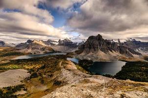 Mount Assiniboine with lake on Nublet peak in autumn forest on sunset at provincial park photo