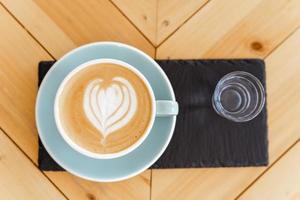 taza de café capuchino caliente en la mesa foto