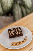 Cup of hot cappuccino coffee on table with fudge cake photo