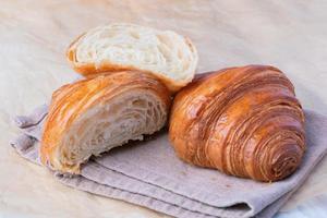 pan de croissants recién hechos en un papel de cocina. desayuno francés foto