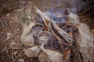 water is heated on a campfire photo