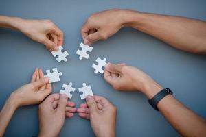 A high-level view of business people who solve puzzles On a gray background photo