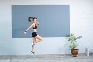 hermosa mujer asiática que está haciendo ejercicio y saltando. foto