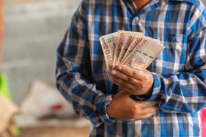 las manos de los trabajadores de la construcción con billetes y teléfonos móviles foto