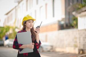 Female construction engineer is using radio for work photo