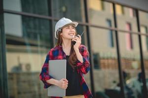 Female construction engineer is using radio for work photo