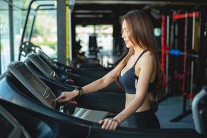 Side view of two attractive sports women on running track. Girls on treadmill photo