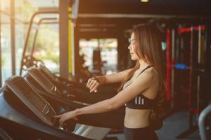Side view of two attractive sports women on running track. Girls on treadmill photo
