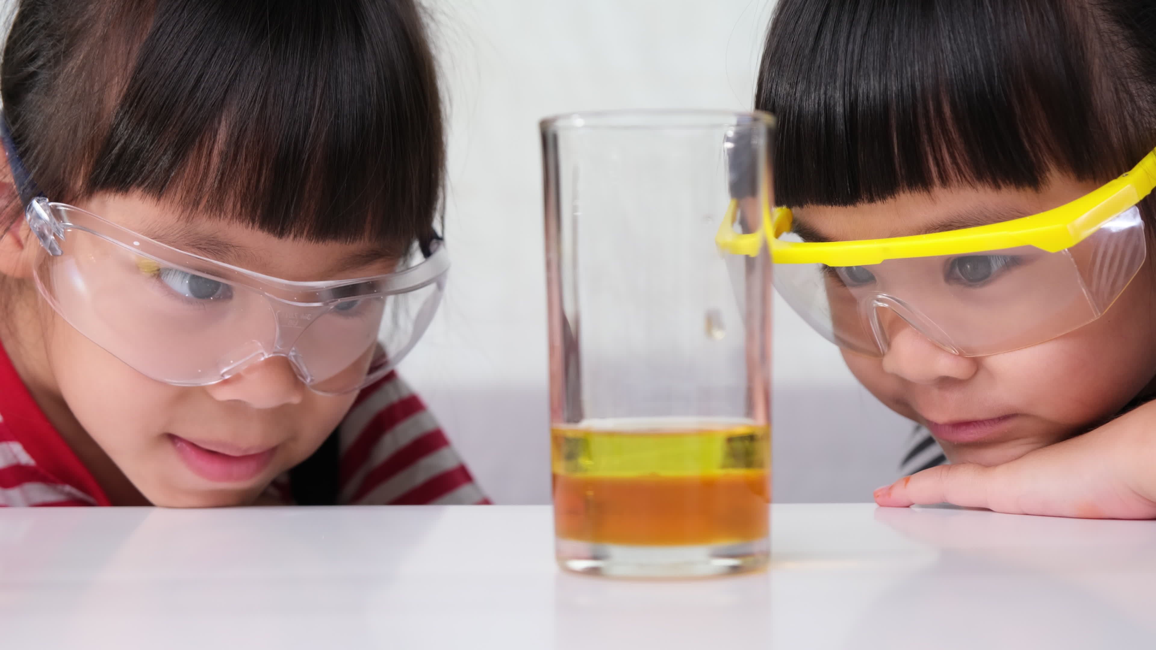 les enfants apprennent et font des expériences scientifiques en classe.  deux petites soeurs jouant à l'expérience scientifique pour l'enseignement  à domicile. des expériences scientifiques faciles et amusantes pour les  enfants à la