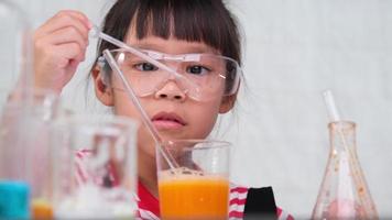 as crianças estão aprendendo e fazendo experimentos científicos na sala de aula. menina jogando experimento científico para educação em casa. experimentos científicos fáceis e divertidos para crianças em casa. video