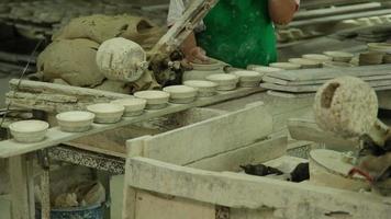 vrouw die kleivoorwerpen maakt in aardewerkatelier. het proces van het maken van een handgemaakte keramische kom. handwerk en klein zakelijk concept. video