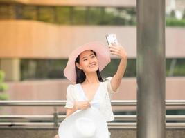 Tourist woman smiling and happy when she take a photo selfie by smartphone