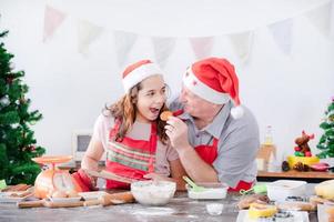 A young European girl and her father tests out the gingerbread she does during Christmas and New Years photo