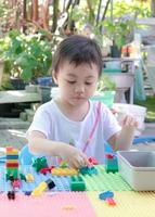 niño en edad preescolar jugando bloques de construcción coloridos creativos en casa. foto