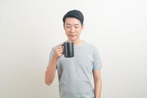 young Asian man holding coffee cup photo