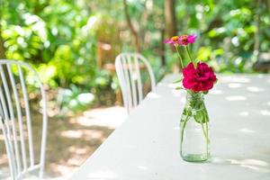 hermosa flor de rosa en un jarrón decorado en la mesa foto