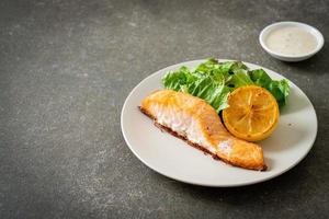 fried salmon steak with lemon and vegetable photo