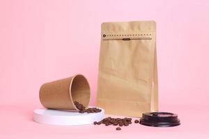 Close-up of coffee set packaging. Take away cup and pouch standing with zip lock isolated on pink background. Realistic set mock up for branding,  template for your design, presentation, promo, ad. photo