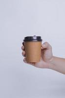 Hand holding paper cup isolated on white background. Realistic set mock up for branding,  template for your design, presentation, promo, ad. photo