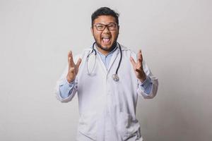 Happy male doctor with shocked screaming gesture isolated on white background photo