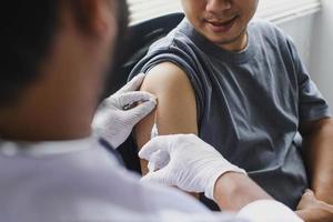 Close up of The arm of the patient who is being injected with vaccine or antibodies on his arm photo