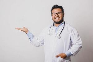 alegre médico masculino que presenta lateralmente aislado en fondo blanco con espacio para copiar foto