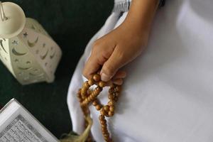 Cerca de manos musulmanas contando dhikr con rosarios foto