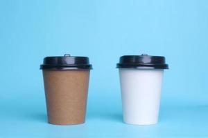White and brown paper cup isolated on blue background. Take away cup. Realistic set mock up for branding,  template for your design, presentation, promo, ad. photo
