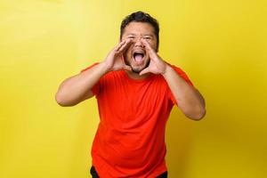 Closeup portrait of upset, angry fat man with hands close to wide opened mouth yelling, isolated on yellow background. Negative emotion, feelings. photo