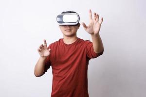 un hombre asiático de estilo informal que usa gafas de realidad virtual hace movimiento, fotografía de estudio, maqueta de marca y espacio de copia para el diseñador publicitario creativo foto